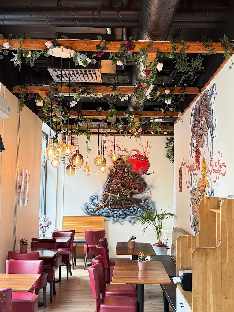 Restaurangens interiör med samurajmålning, blomsterdekor och röda stolar