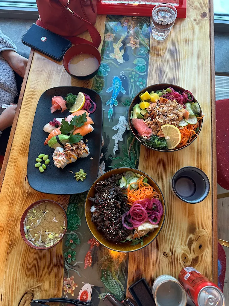 Sushi, nigiri och poke bowls uppdukade på ett träbord hos Megumi Sushi